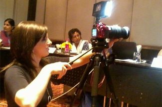 Lindsey Mastis operates her own camera as she reports from the field.