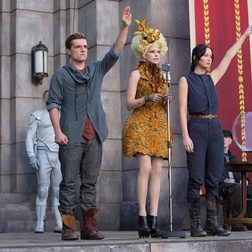 Characters salute in a scene from The Hunger Games Catching Fire.