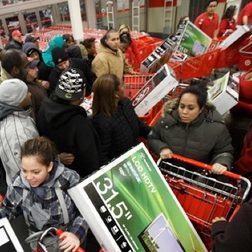 A Black Friday shopping mob with TVs in shopping carts.
