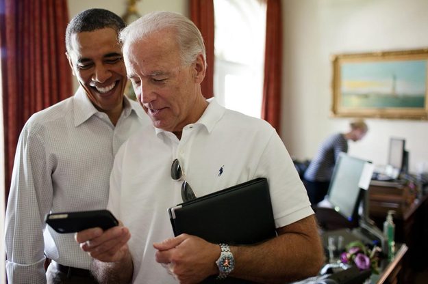 President Obama, Vice President Biden looking at an iPhone