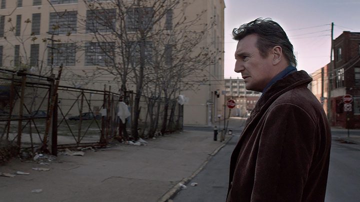A man looks at an empty street in A Walk Among the Tombstones.