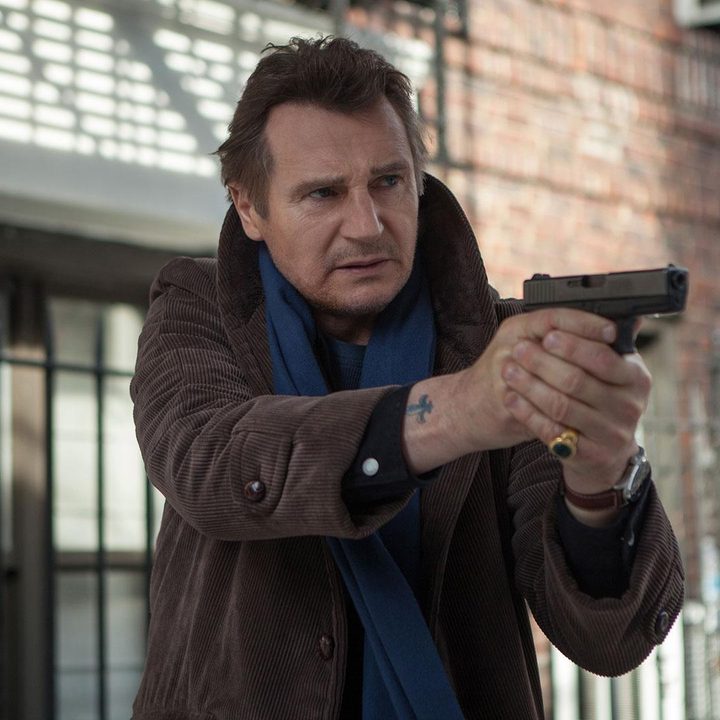 Liam Neeson holds his weapon in A Walk Among the Tombstones.