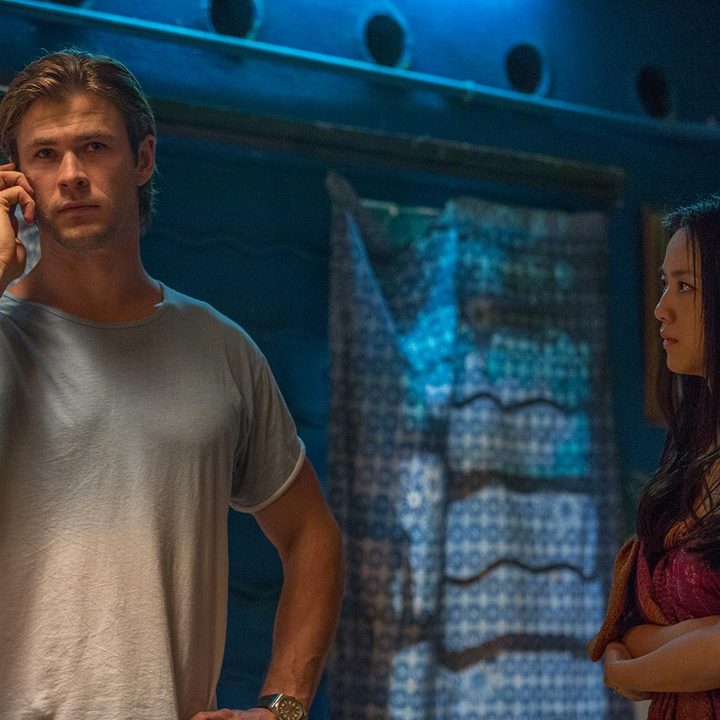 Chris Hemsworth on a cell phone while standing next to a woman.