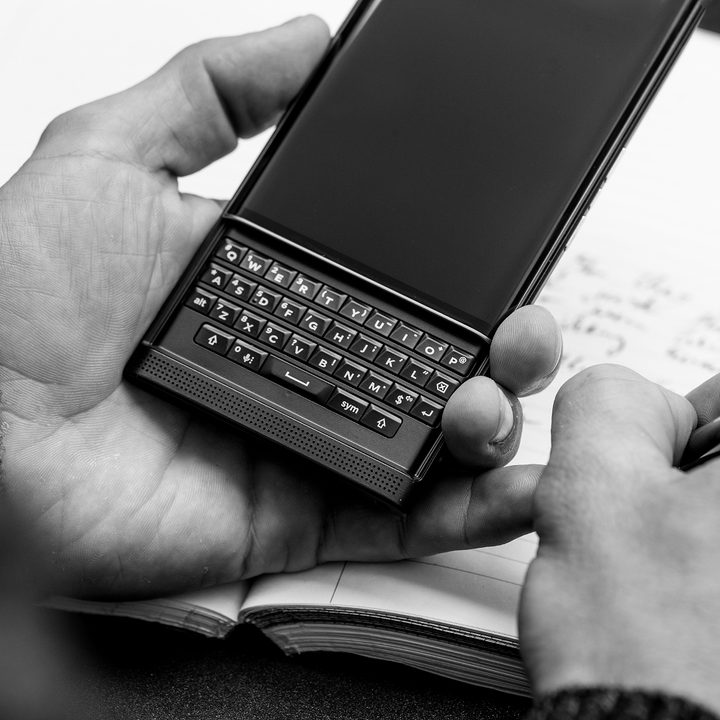 BlackBerry Priv in hand while note-taking in the other.