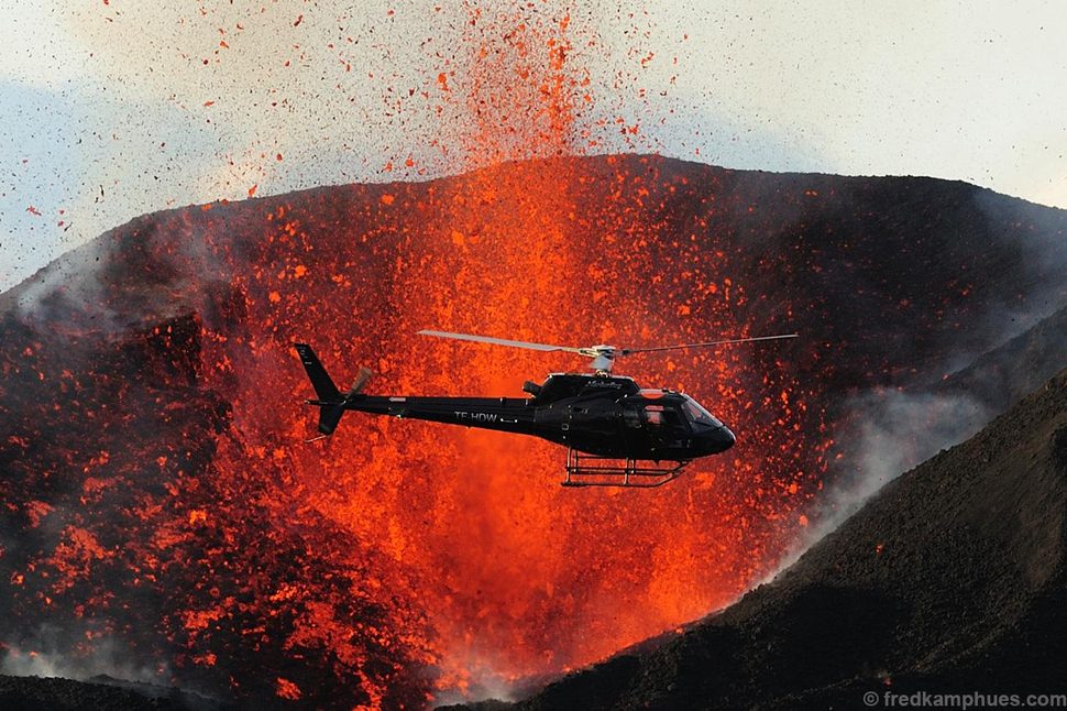 A helicopter flies close to one of the craters of the 2010 Fimmvörðuháls eruption in Iceland.