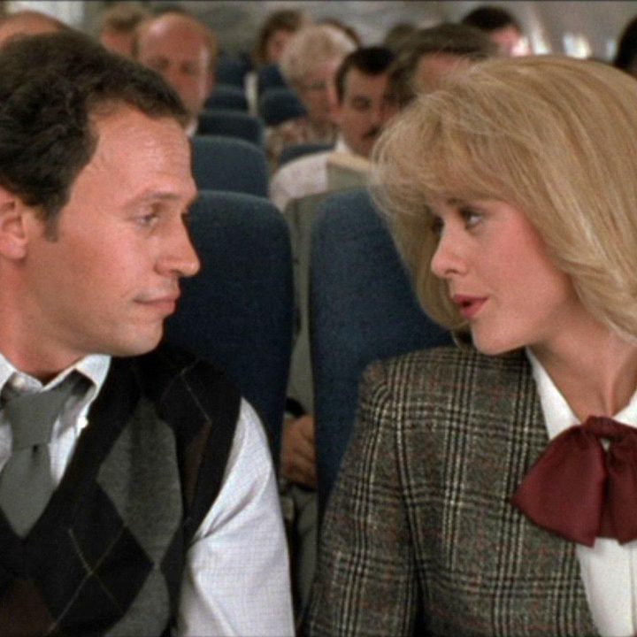 Two people sit next to each other on an airplane.
