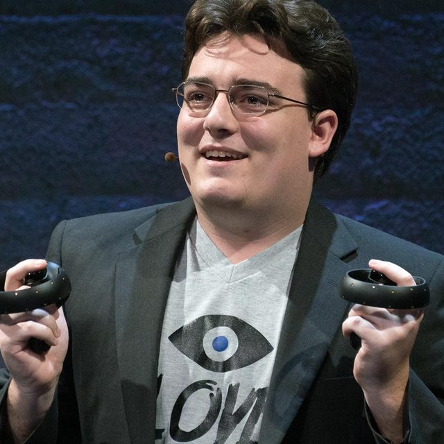 Oculus founder Palmer Luckey holds up Oculus Touch prototype controllers.