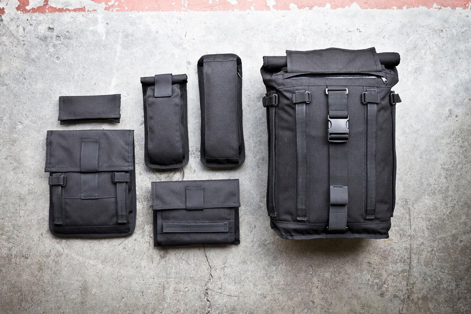 A Mission Workshop&nbsp;R6 Arkiv Field Pack and its various accessories arranged next to each other.