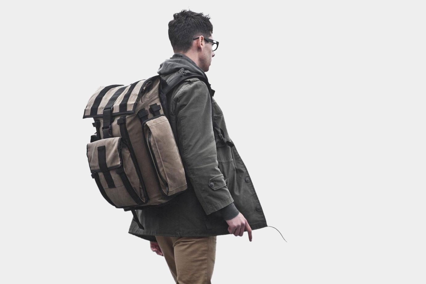 Rear profile view of a person wearing a tan Mission Workshop&nbsp;R6 Arkiv Field Pack.