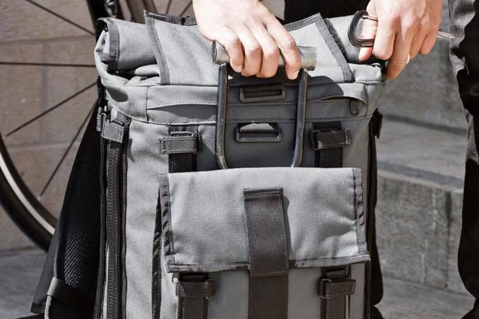 Front view of a person hand opening a Mission Workshop&nbsp;R6 Arkiv Field Pack.