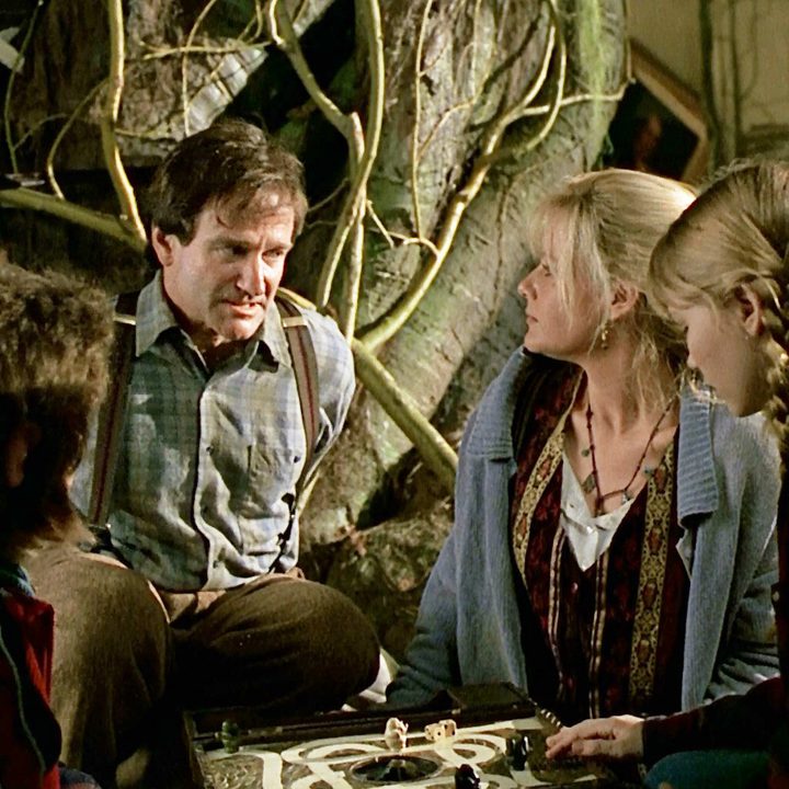 Robin Williams, Bonnie Hunt, and the kids sit around a table in Jumanji.
