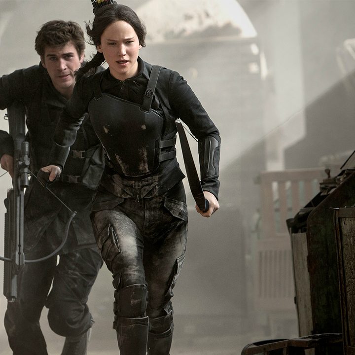A man and woman run toward a fight in Mockingjay.