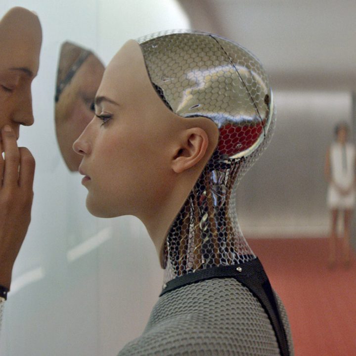 An android touches a face on the wall in Ex Machina.