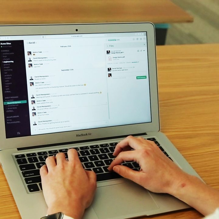A person using Slack on a Macbook.