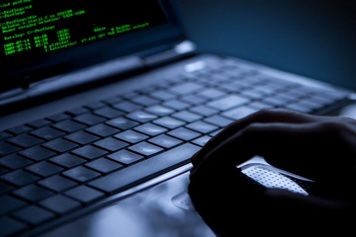 A hand on a darkened keyboard.