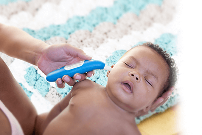 A person reading a baby's temperature with a smart thermometer.