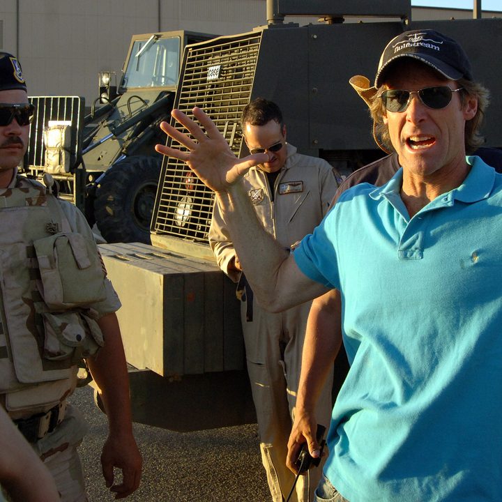 Michael Bay holds his hand up on Transformers set.