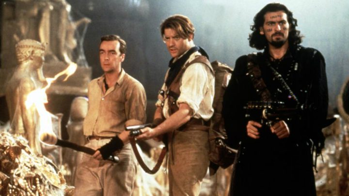Three men hold guns and point.