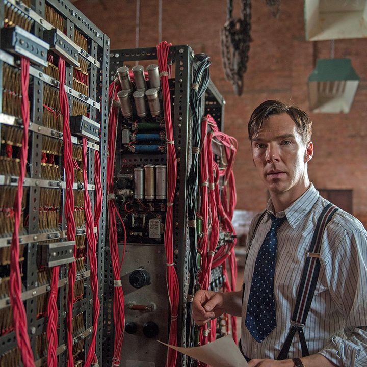 Benedict Cumberbatch stands next to a codebreaking machine in The Imitation Game.