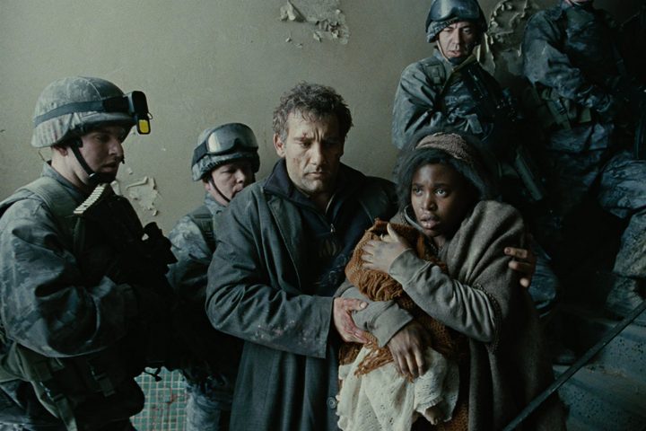 A pregnant woman is ushered through a hallway in Children of Men.