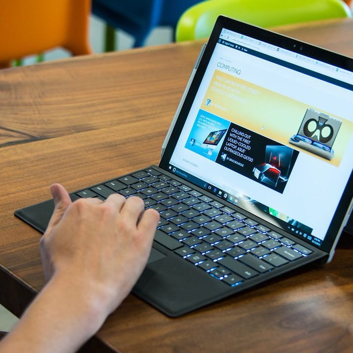 Someone using a Surface Pro 4 on a table.