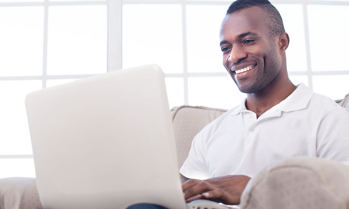 A person sitting down and using a laptop.