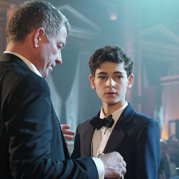 Sean Pertwee and David Mazouz as Alfred and Bruce Wayne at a party in the TV show Gotham.