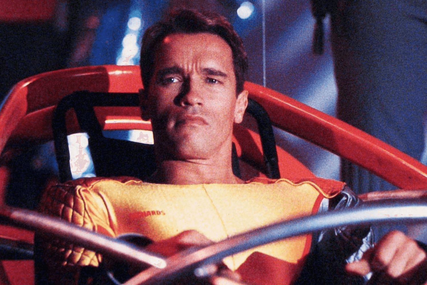 Arnold Schwarzenegger looks on with a scowl.