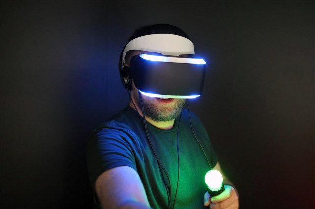 A man playing with a PS VR headset and Move controllers.