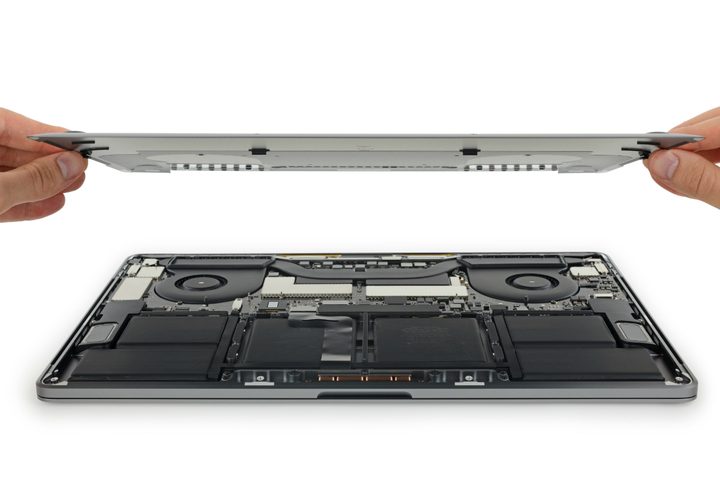 Someone removing the back cover on a MacBook Pro.