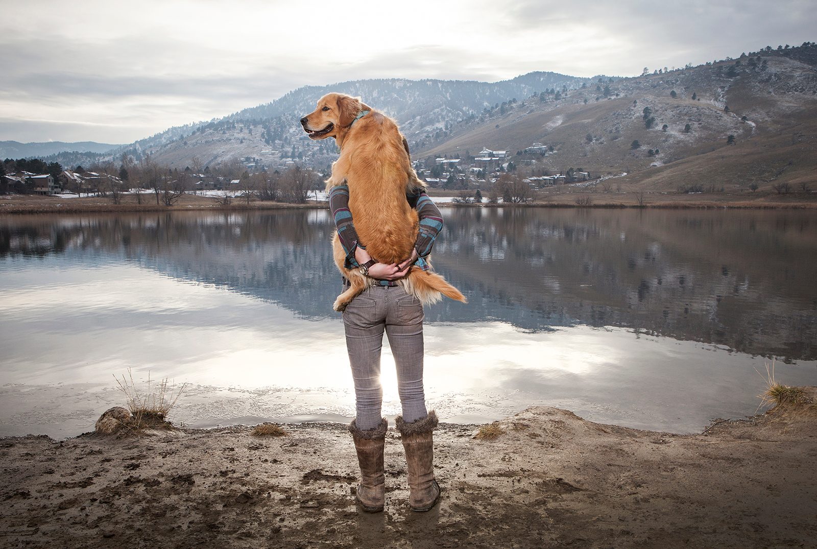 2017 photography trends woman holding her golden retriever at lake