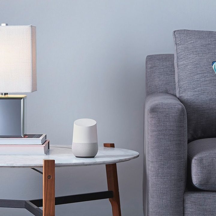 A Google home on a side table by a couch.