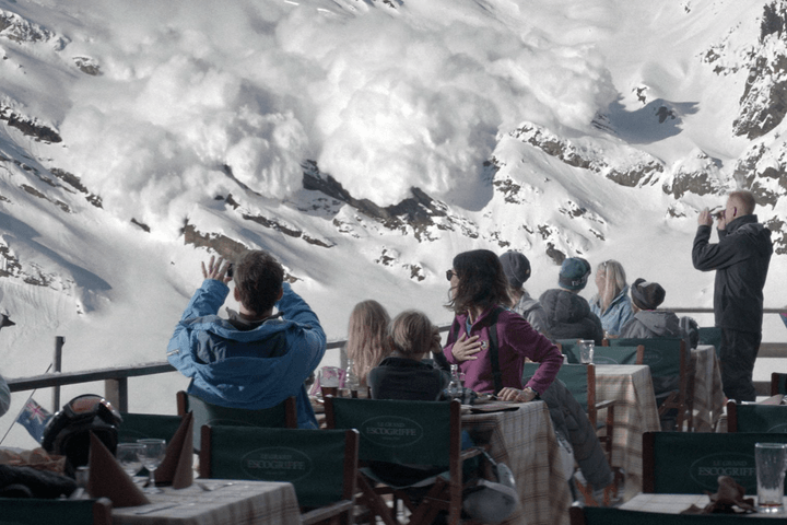 A group of people stare at an avalanche.