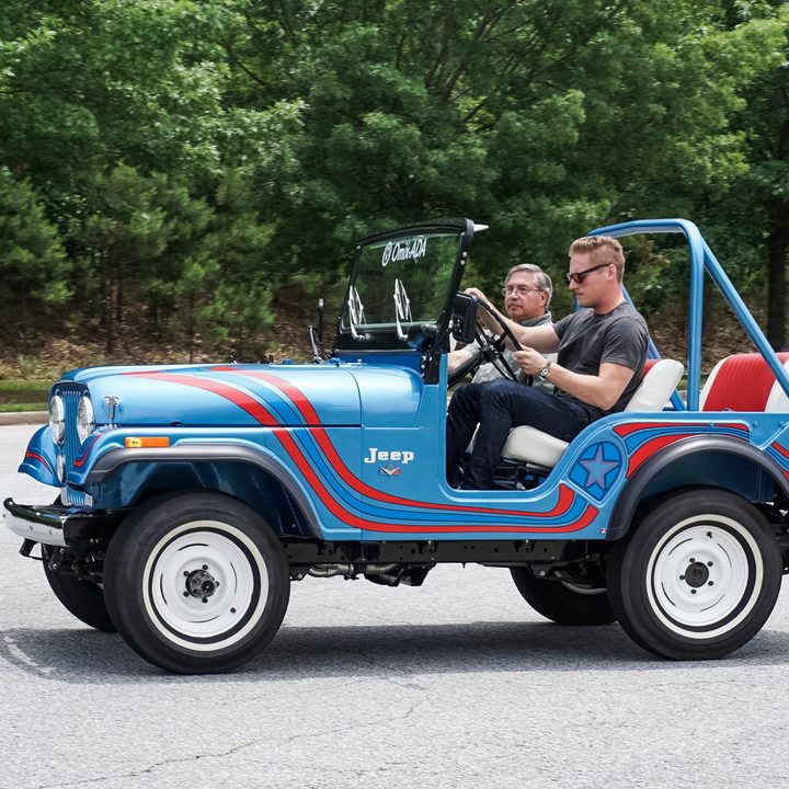 Side shot of blue with two red ribbon stripes classic jeep