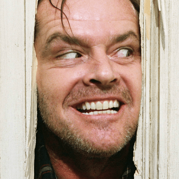 Jack Torrance looking through a hole in a door in "The Shining."