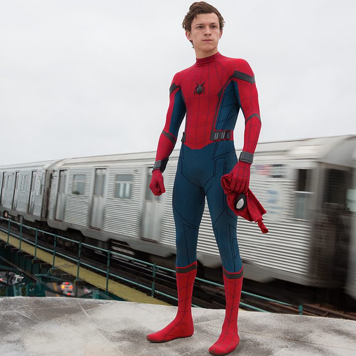 Spider-Man with his mask off standing atop a train in Spider-Man: Homecoming.