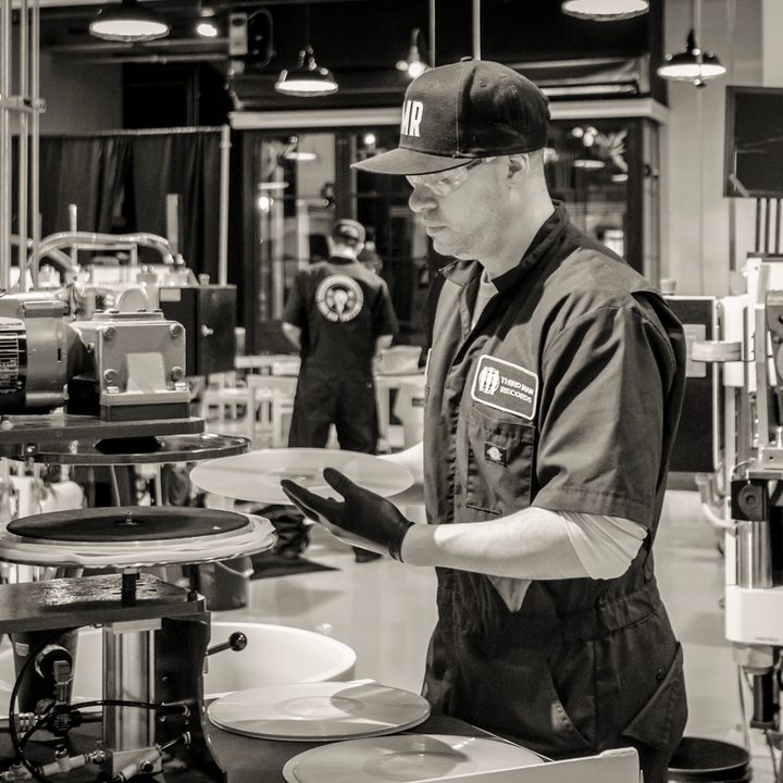 man-making-vinyl-record-in-machinery