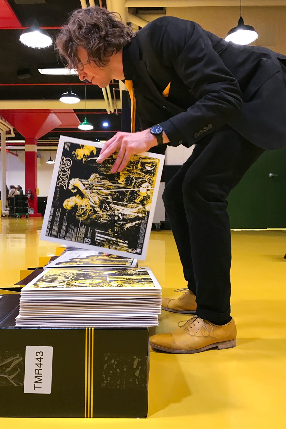 man-picking-up-stacks-of-vinyl-in-covers