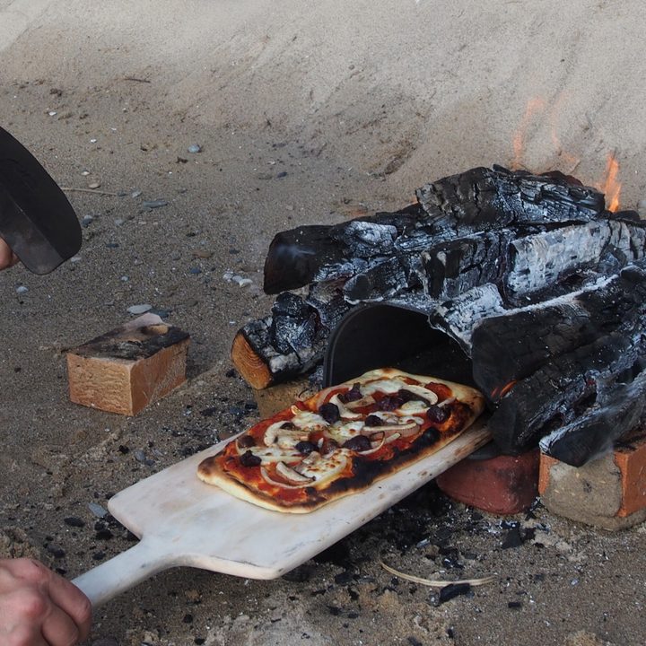 weekly rewind pizza being baked on beach