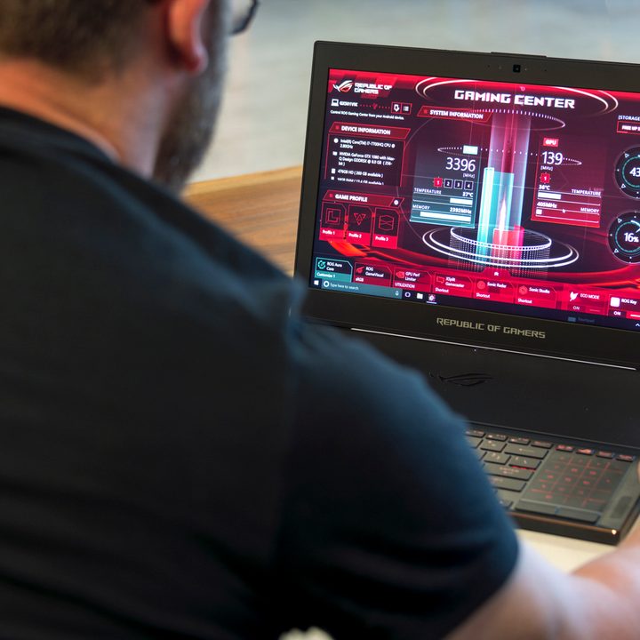 Asus ROG Zephyrus over the right shoulder shot of a man using the laptop on the gaming center screen