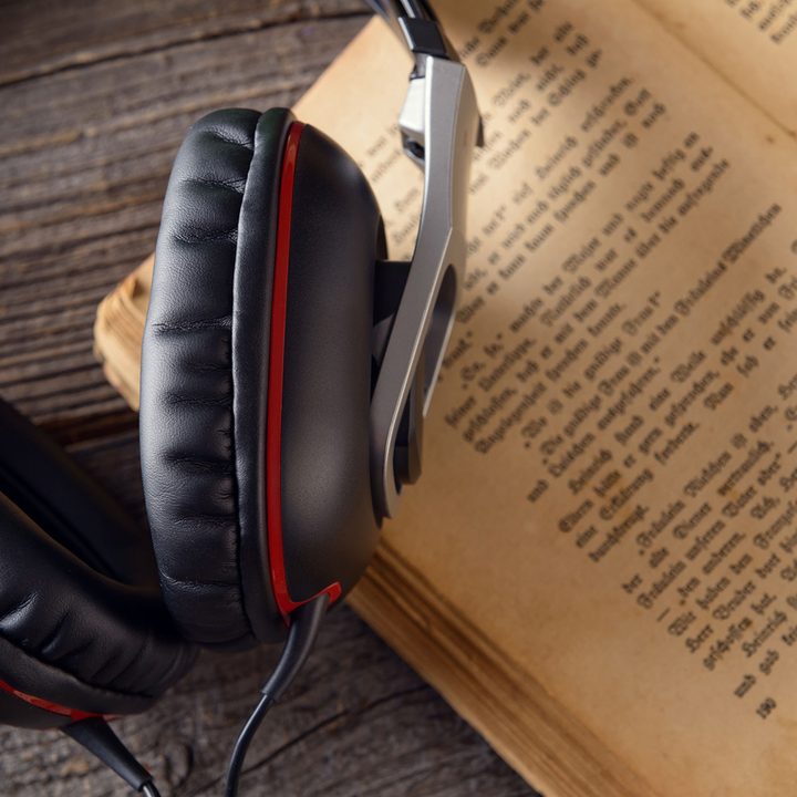 A pair of headphones with a book.