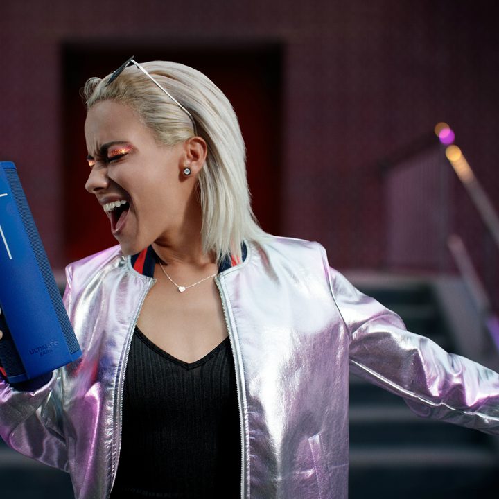 Woman holding to Ultimate Ears UE Megablast Blue Steel.
