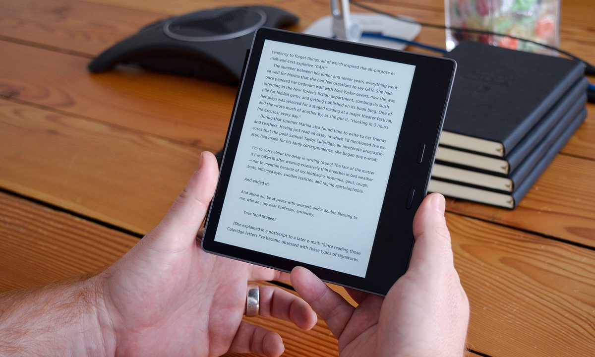 A man reads a text on an Amazon Kindle Oasis.