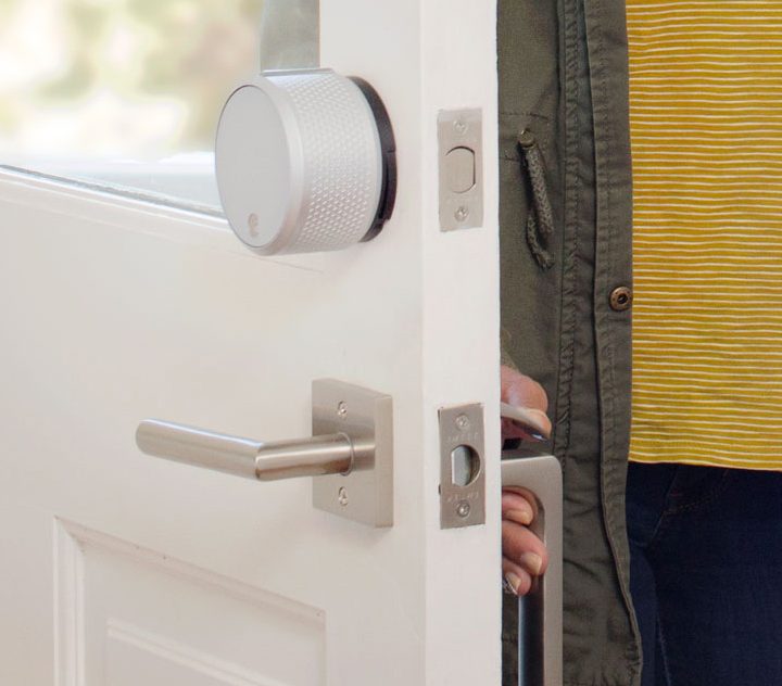 An August Smart lock installed on a door.