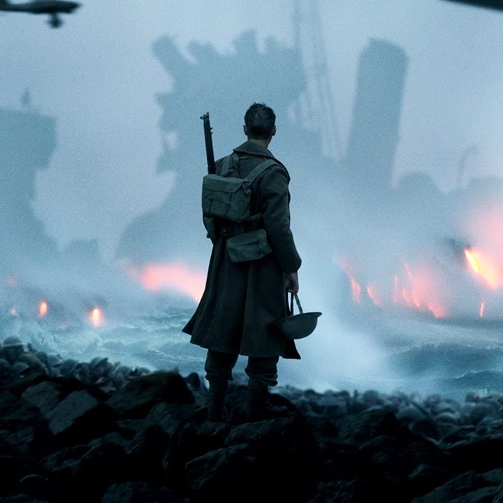 A World War II soldier looks out over a war-torn landscape in a scene from Dunkirk.