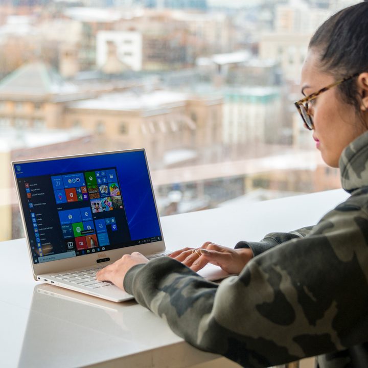 Dell XPS on table in front of a window.