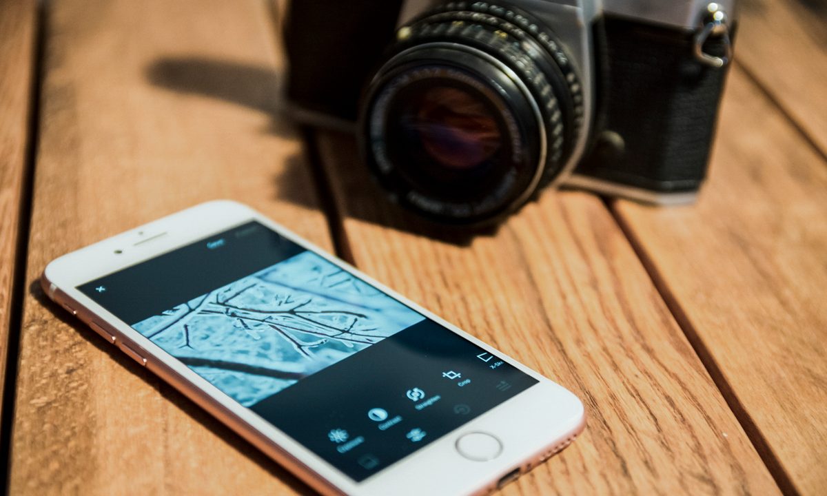 VSCO X Review — Phone and App Close-Up Next to Vintage Camera on Table