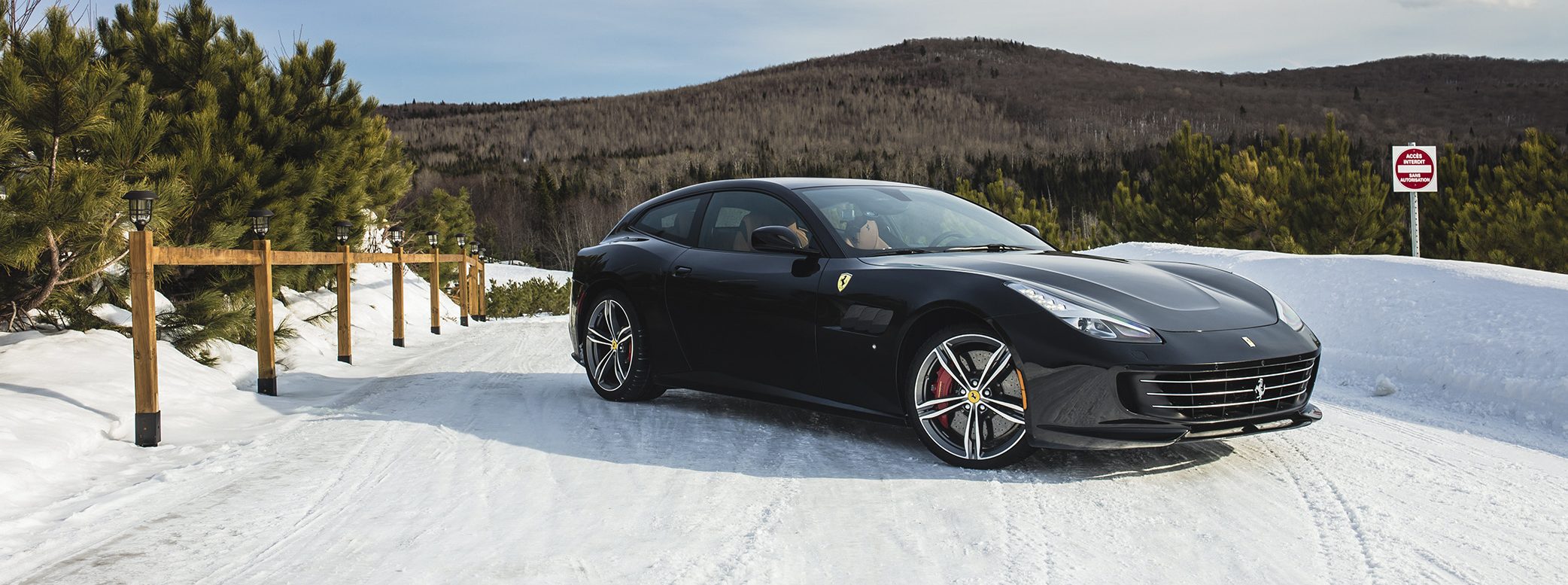 2018 Ferrari GTC4Lusso First Drive | Hero shot of car on snowy road above forest
