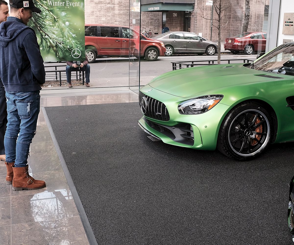 Car dealership with a sports car and salesman pitching to a customer