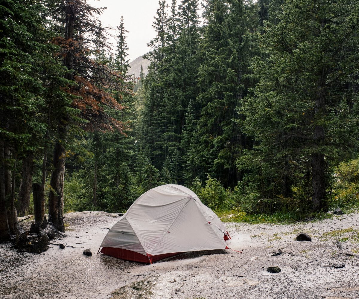 Tent in the middle of a rainy forest.